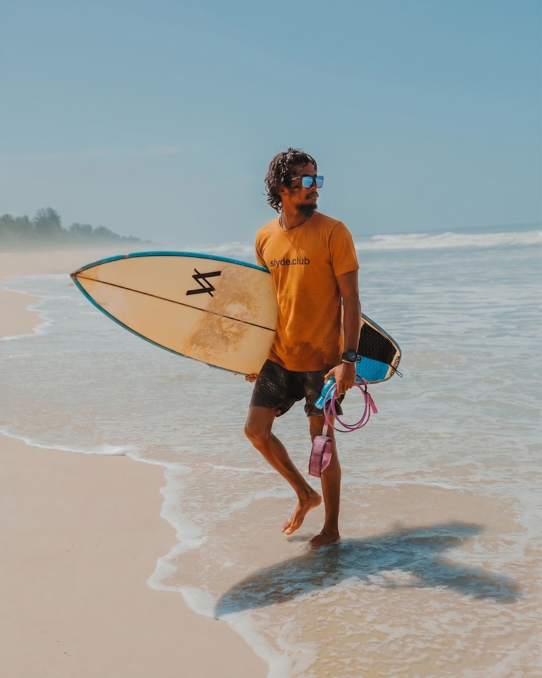 Movin walking out of the shallows at Panambur with a white surfboard under his arm